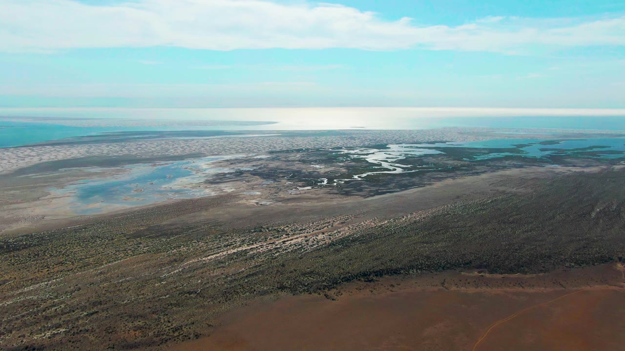 Aerial landscape with coastal flats under partly cloudy sky