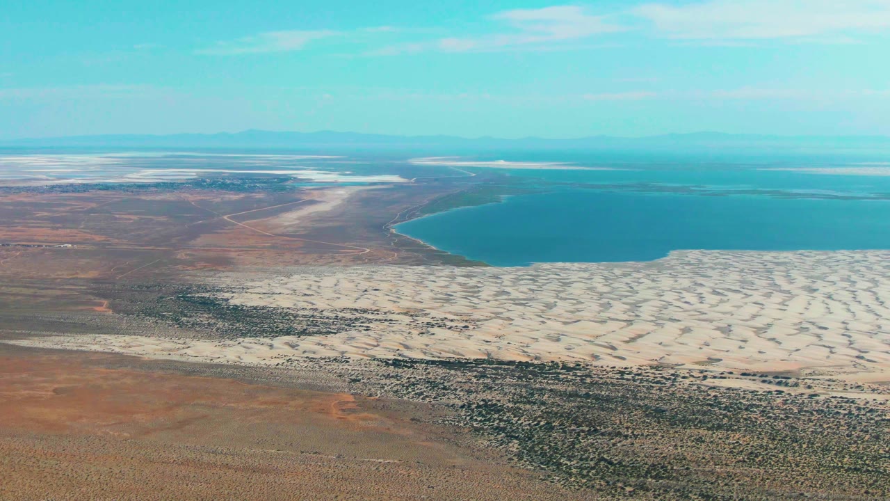 Aerial lake shoreline with desert flats and dunes