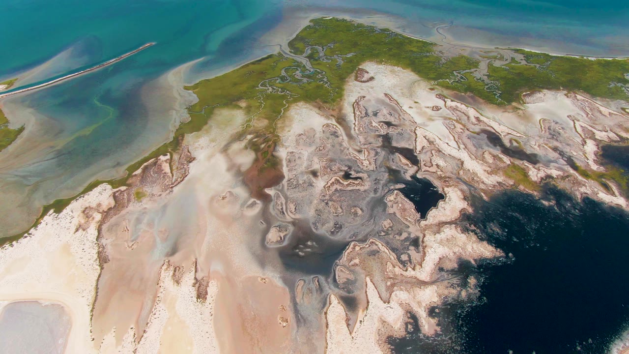 Aerial coastline with pale sand and green land