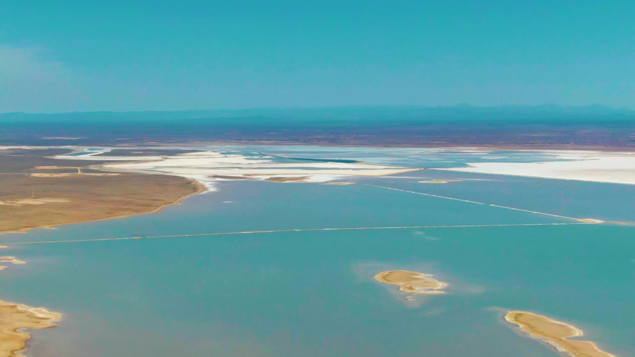Midway through the clip, the Guerrero Negro view shows shallow blue-green water meeting tan land and white salt flats, with the mountain horizon visible and no visible people.