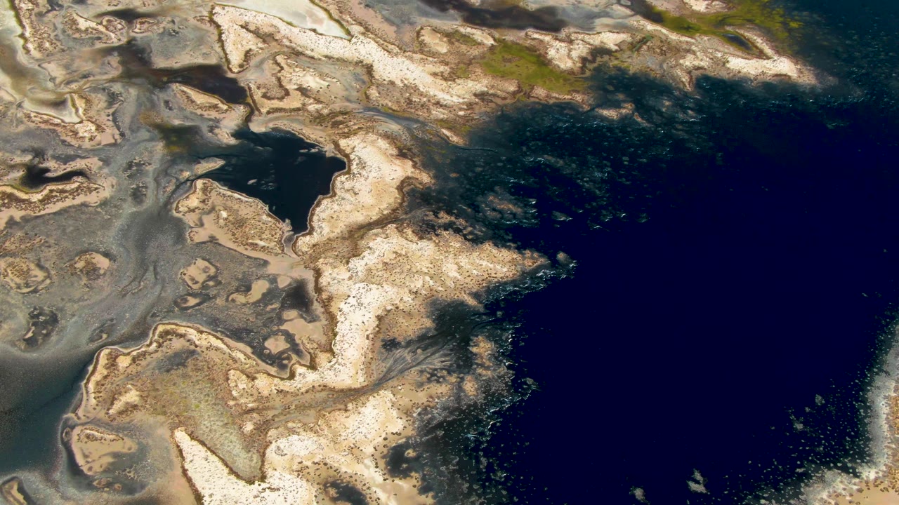 The Guerrero Negro aerial view shows a large dark water mass on the right and pale receding coastal formations along the left edge, with no visible people.