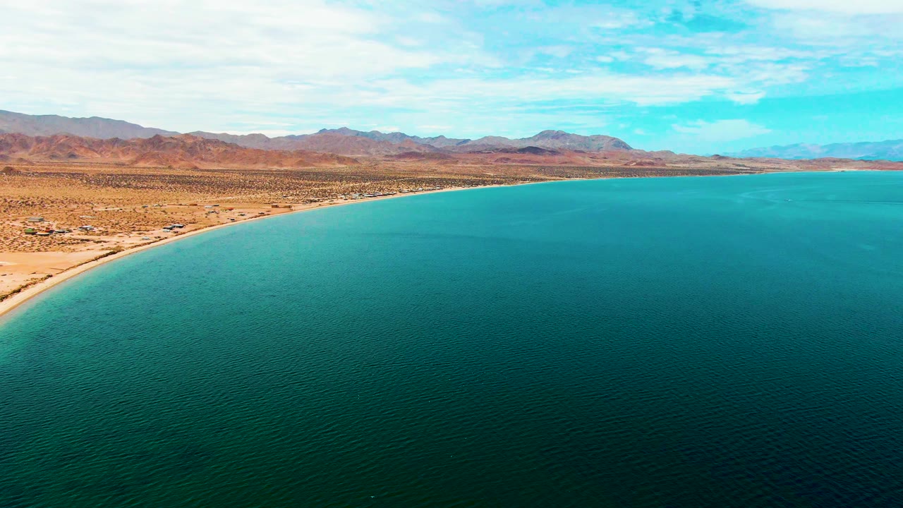 Desert beach and calm turquoise water from above.