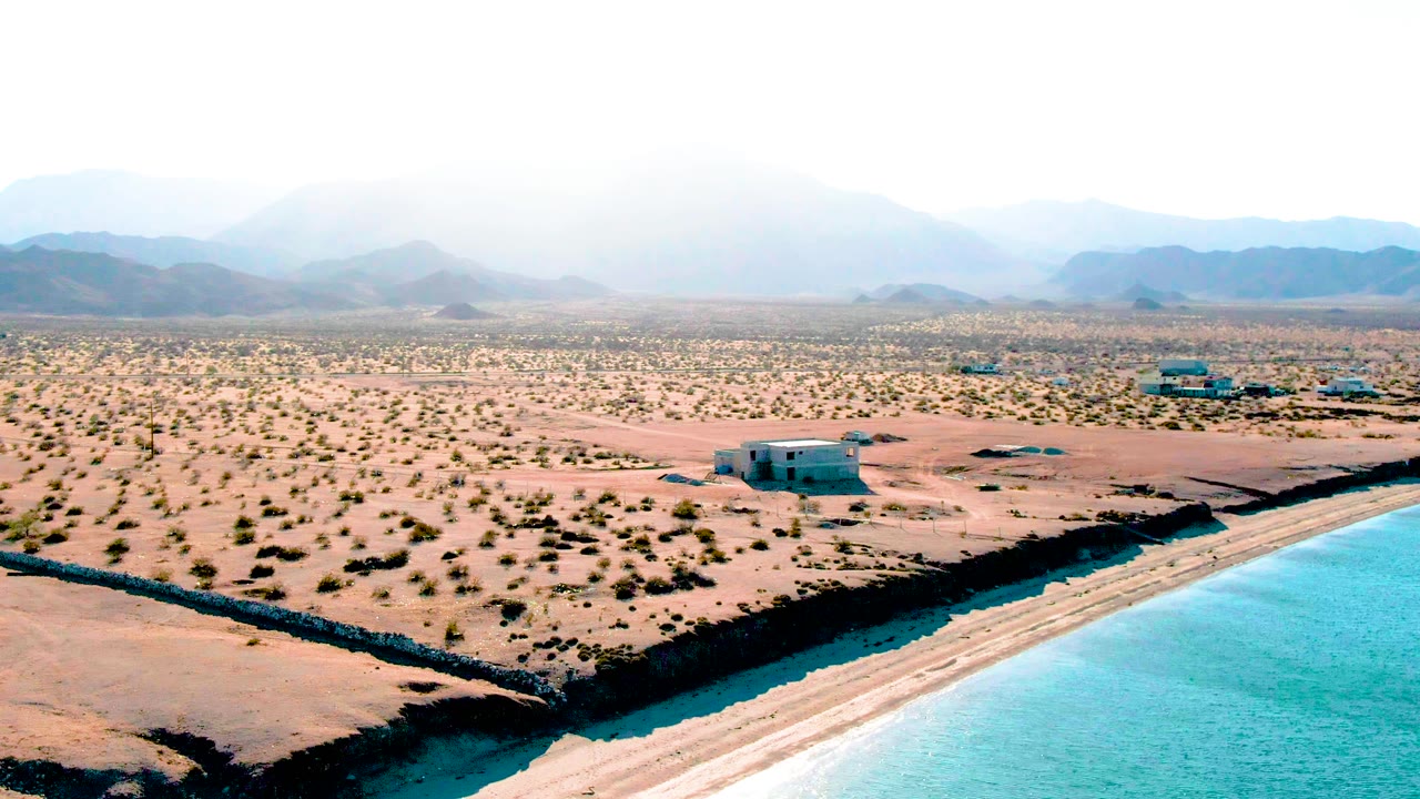 Elevated view of a canal or shoreline running past desert scrub