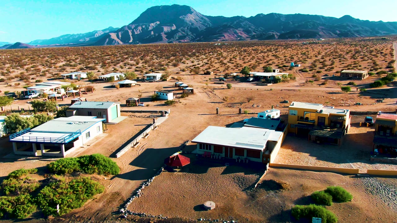 Drone view of low desert buildings and open sandy lots