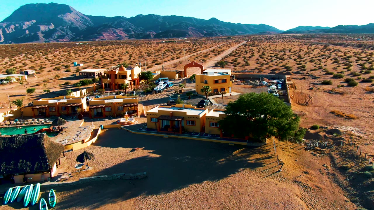 Drone view over yellow buildings and sandy desert plain