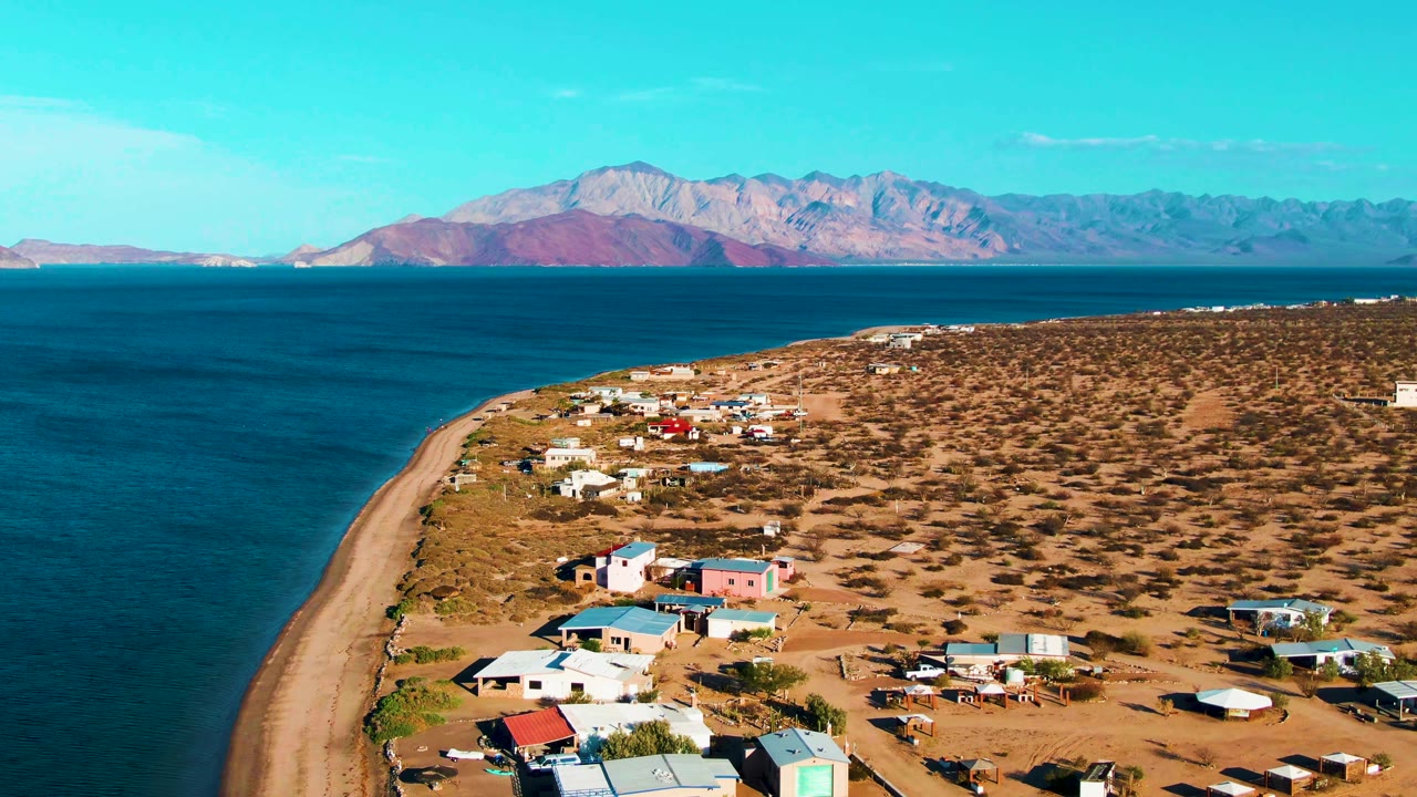 At two seconds, the aerial composition over Bahia De Los Angeles shows more open scrubland to the right, the ocean to the left, and no visible people.