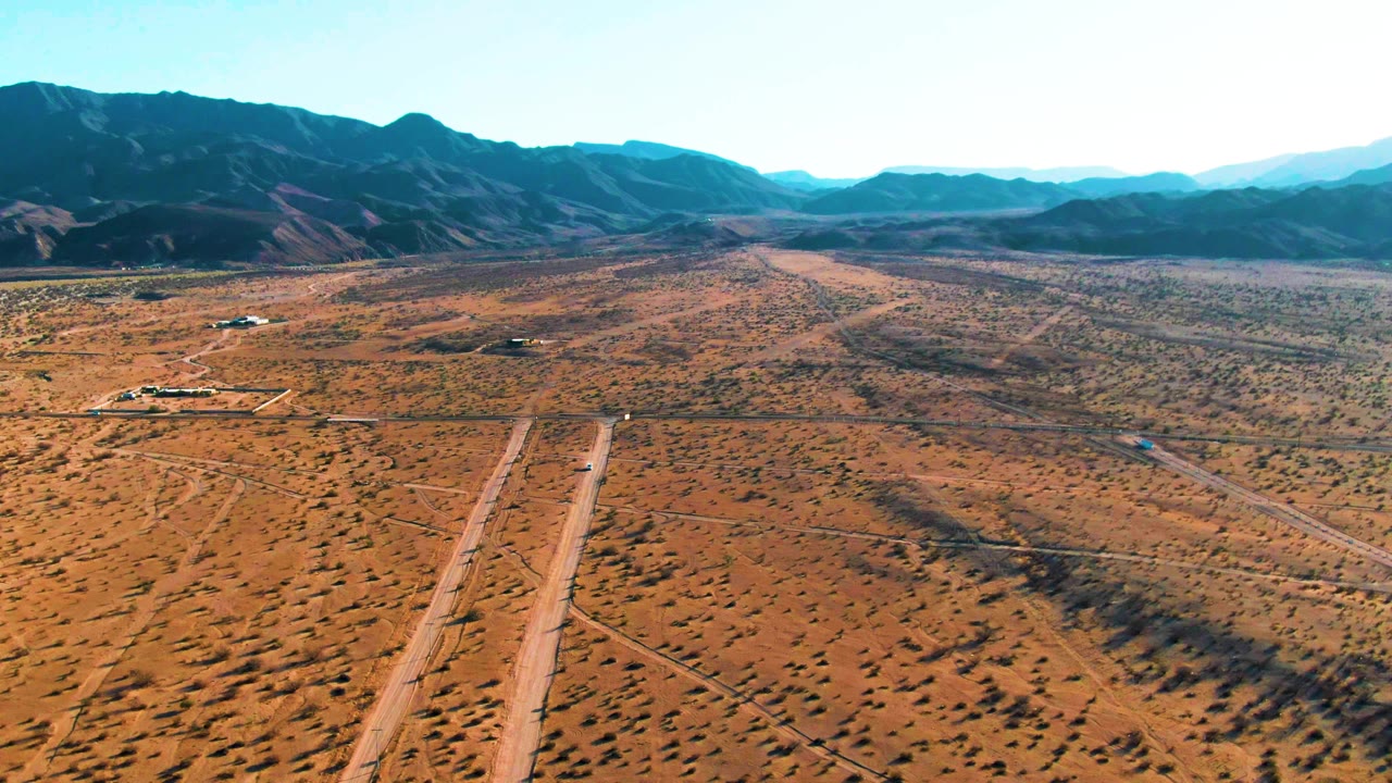 Aerial view of intersecting dirt roads across arid terrain