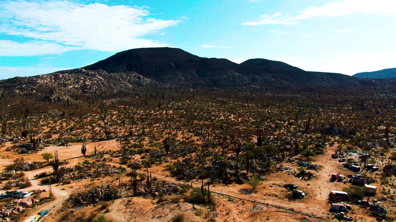 Aerial desert campsite with cacti and dark mountains