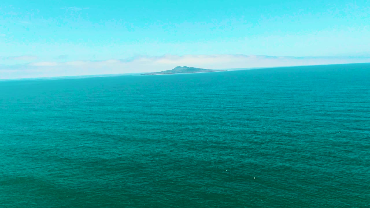 At 0:02, the San Quintin BC, Mexico view keeps the low island near the upper center-right, with open turquoise sea below and no visible people.