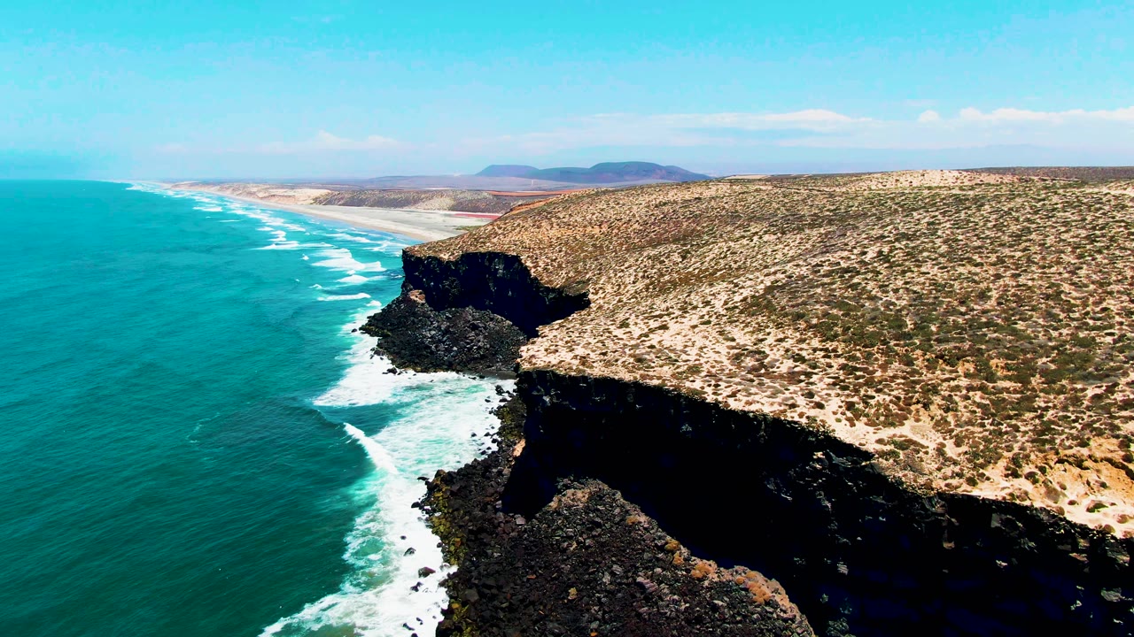 Aerial view of turquoise ocean and rocky coastal cliffs