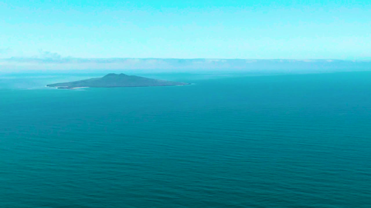 Opening frame of a small island off San Quintin BC, Mexico, set near the horizon above calm turquoise ocean with no visible people.
