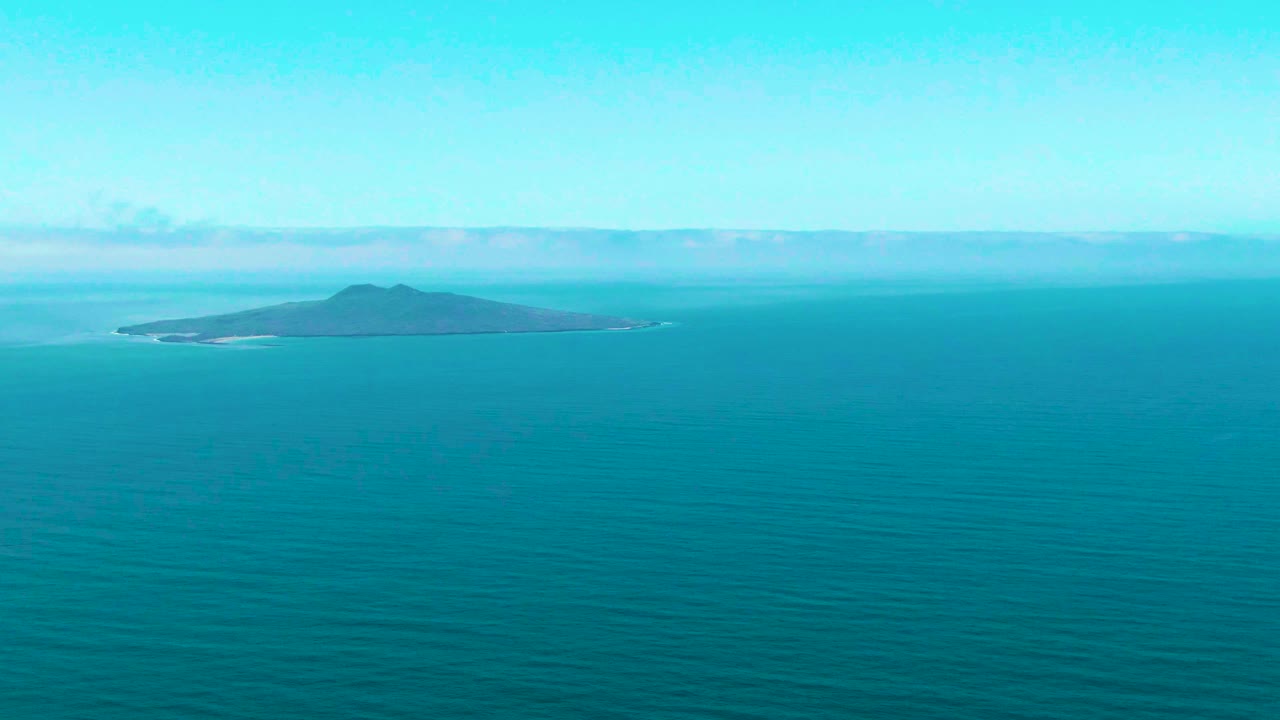 Second frame shows the San Quintin BC island more centered, with pale cloud bands behind it and no visible people on the water or land.