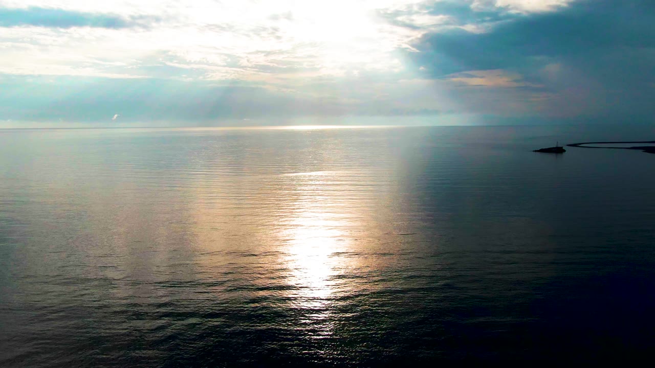 Wide sea horizon with sunlight reflected on calm water