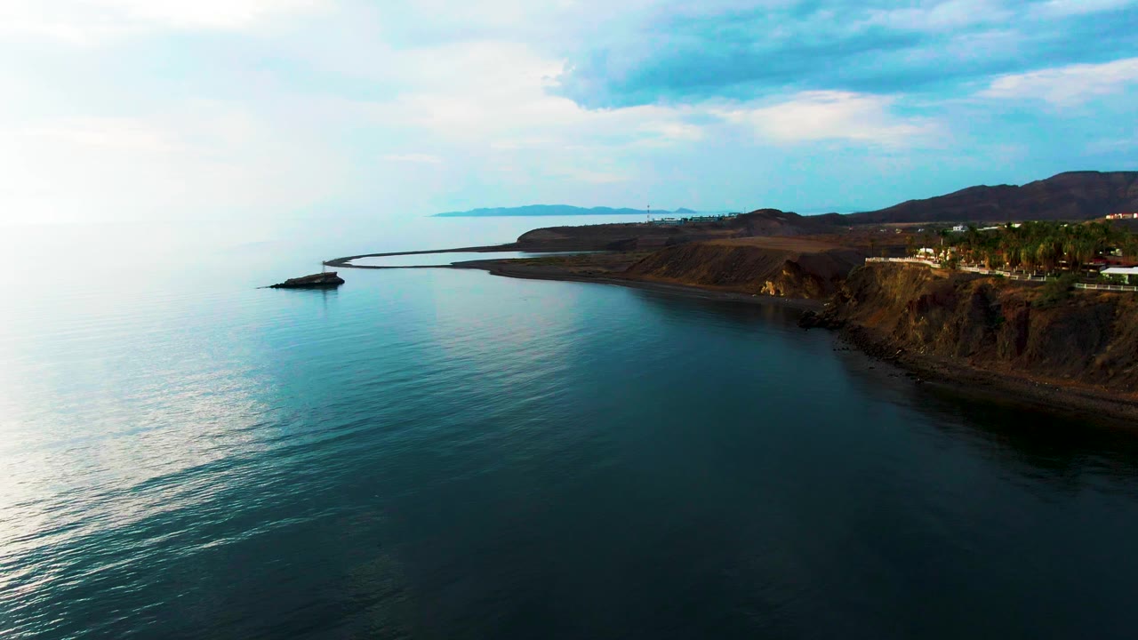 Calm blue sea and cliff-lined coast from above
