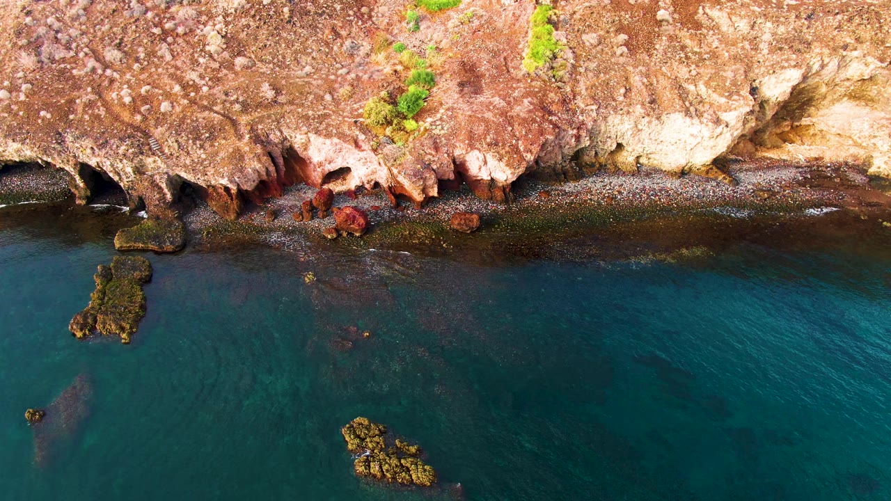 Overhead rocky coast with turquoise water and offshore rocks