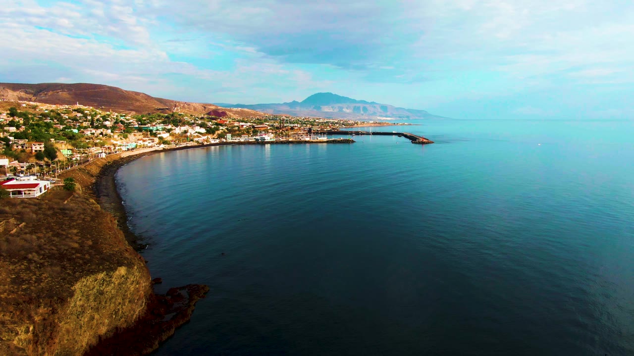 Curved coastal bay with town buildings along the left shoreline.