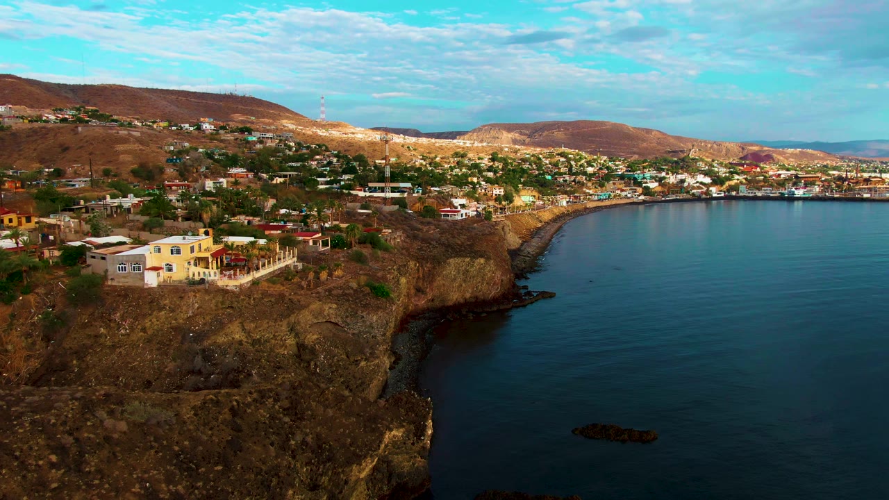Aerial view of houses on rocky cliffs beside a bay.