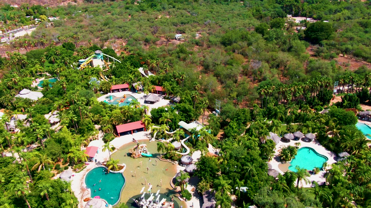 Aerial resort pool area surrounded by trees