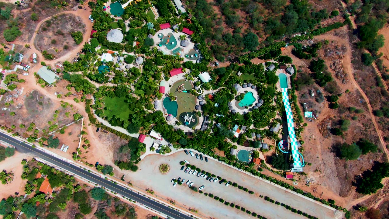 Overhead pool resort beside road and brown hillside