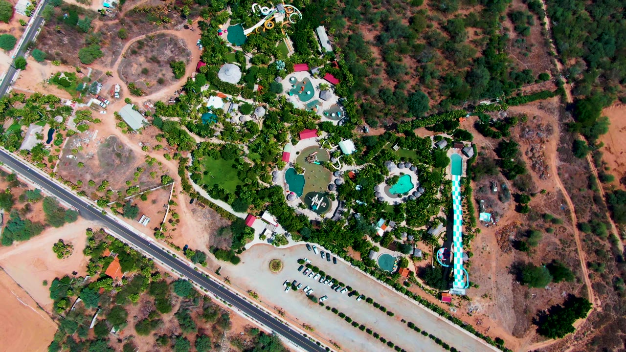 Overhead view of a road beside a resort with pools and slides
