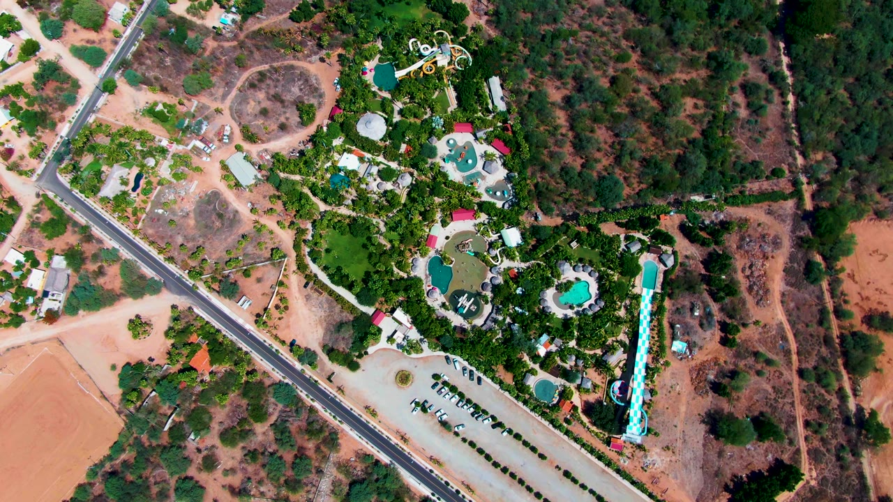 Overhead frame of a roadside resort with pools and green landscaping.