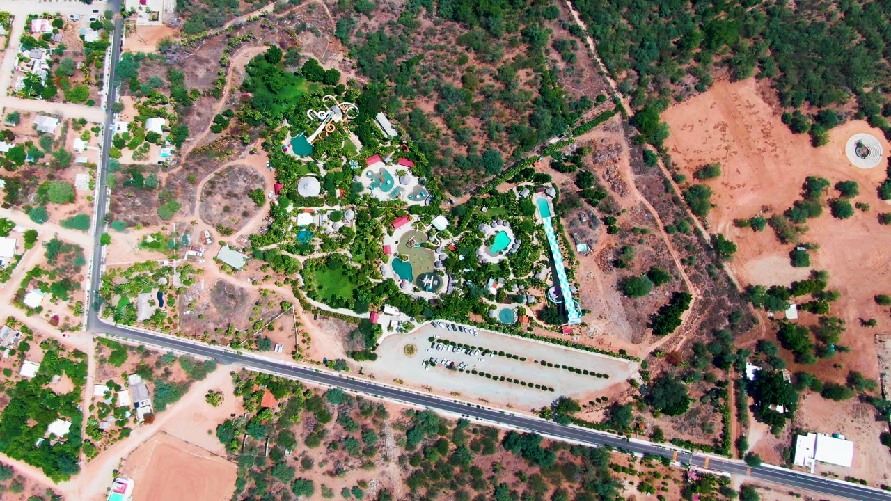 Overhead pool area with road, vehicles, buildings, and trees