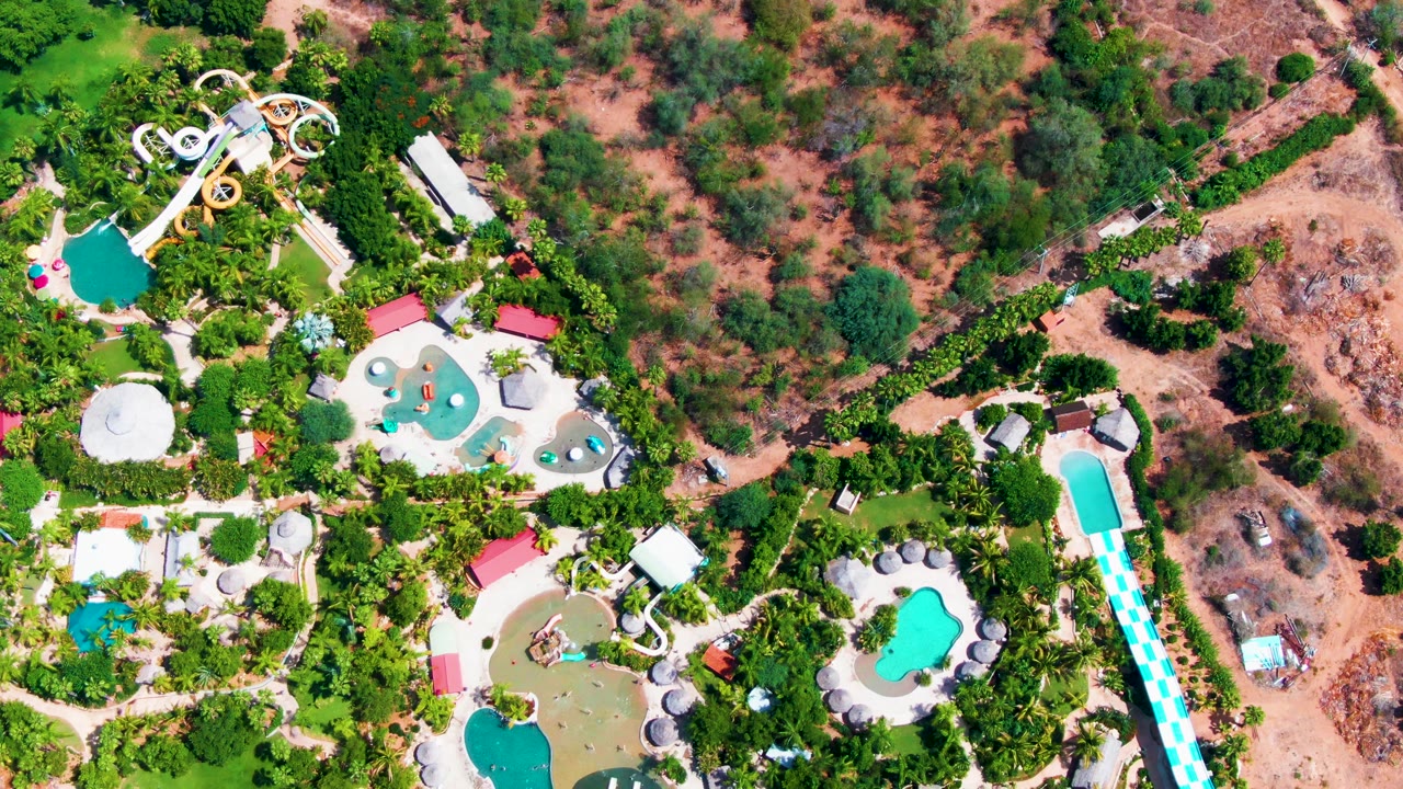 Aerial view of pools and water slides surrounded by greenery.
