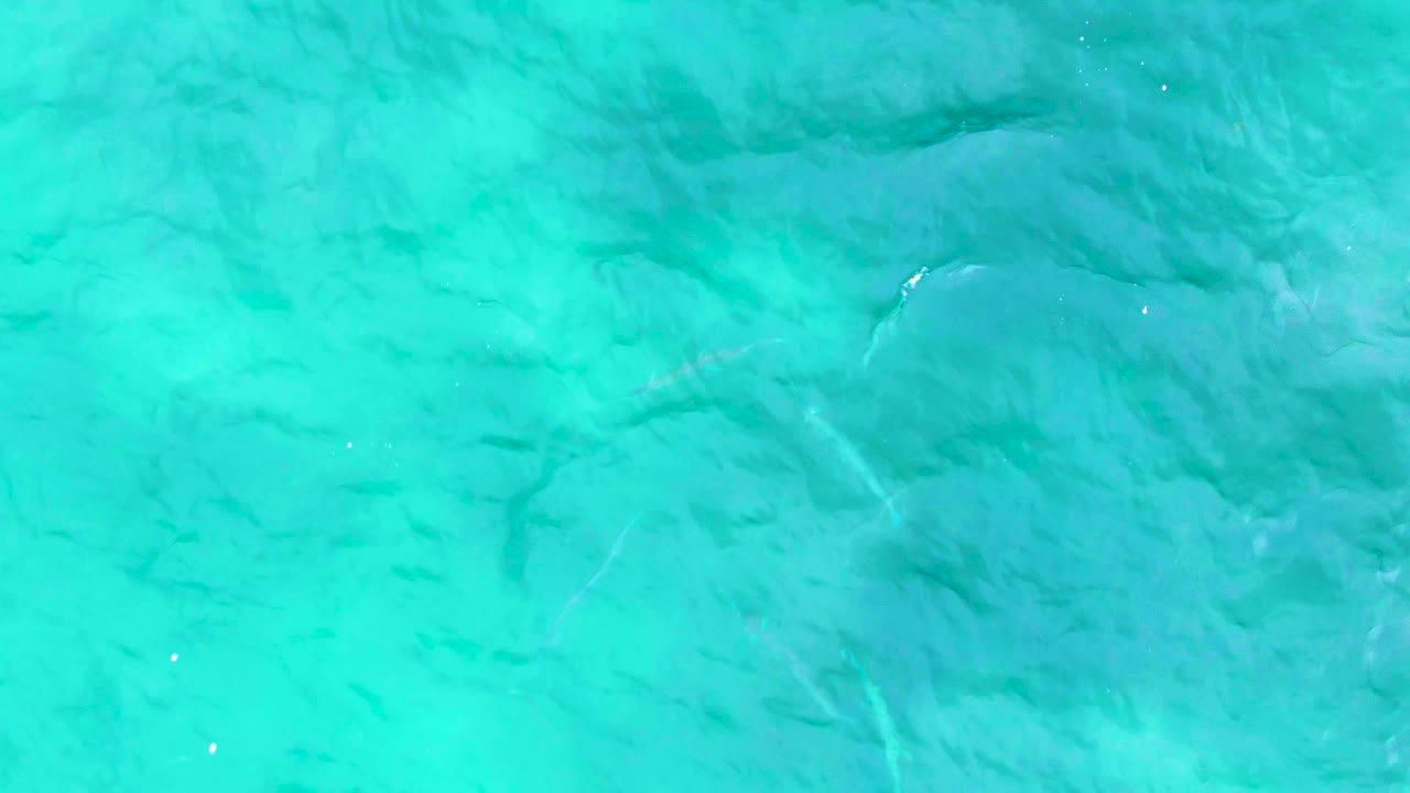 Blue-green ocean water with darker underwater patches