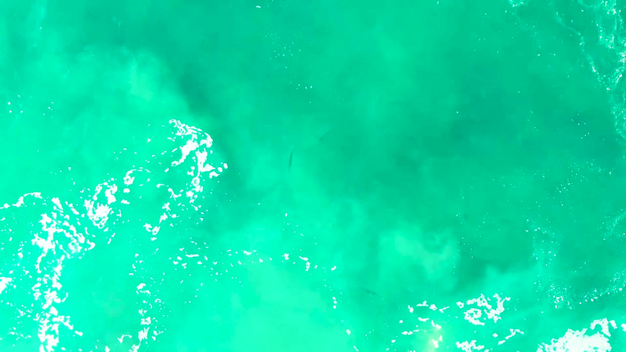 Overhead turquoise ocean with white wave foam.