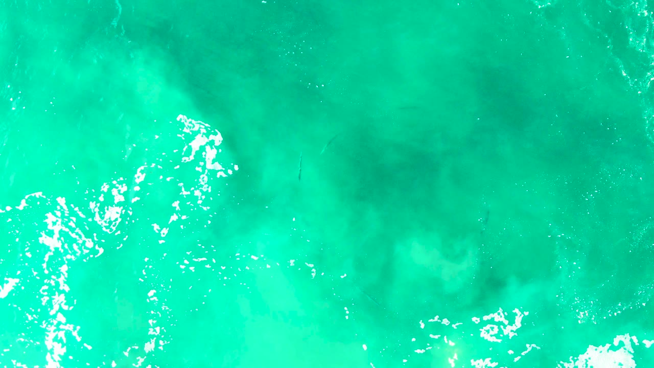 Overhead Buzzards Beach ocean surface with a bright white foam cluster near the center-right, darker water patches around it, and no visible people.