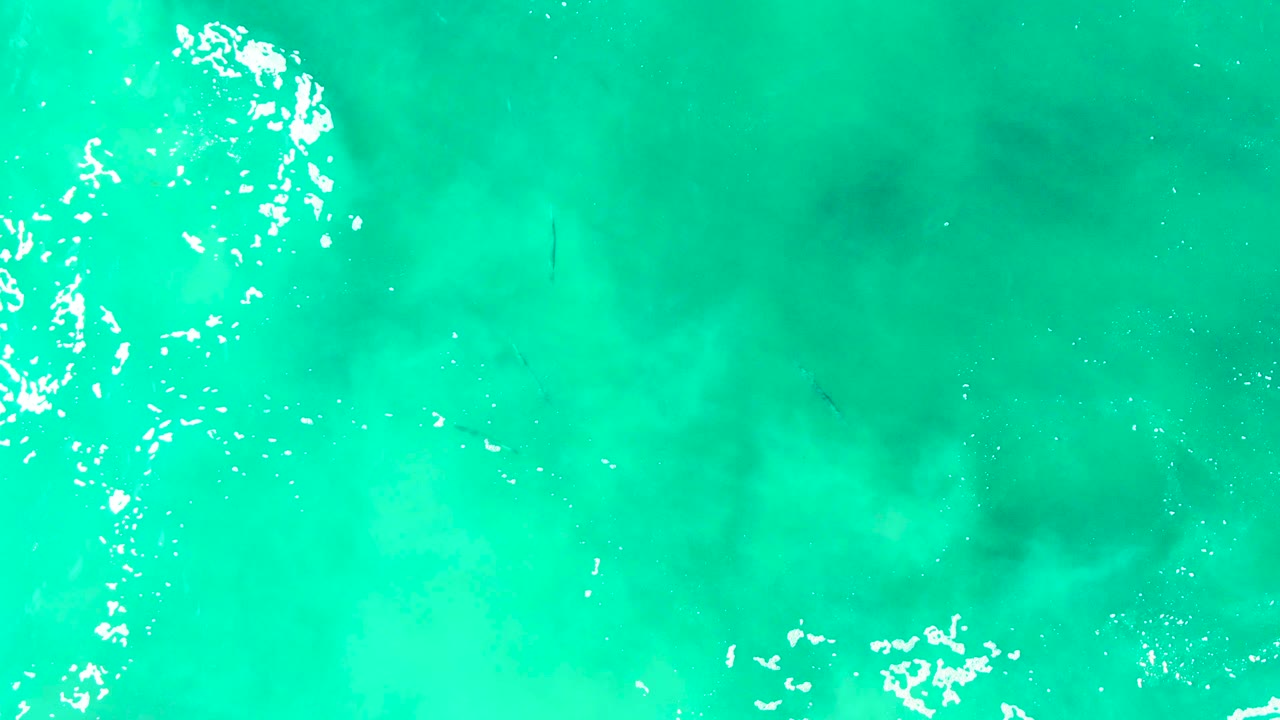 Blue-green water with a vertical band of bright foam