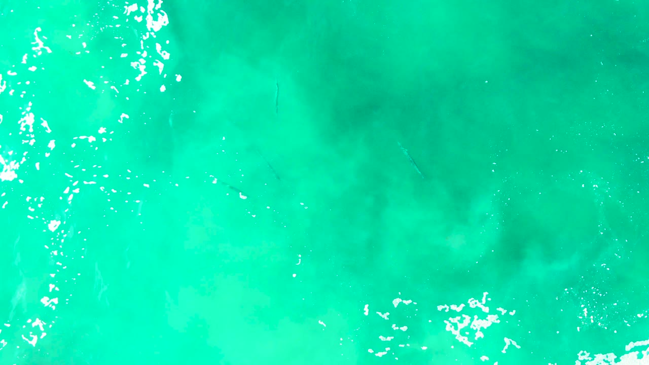 Overhead Punta Buzzards ocean view with bright white foam broken across the upper area and no visible people.