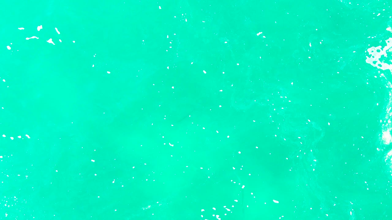Turquoise water with a brighter foam streak near the right edge.