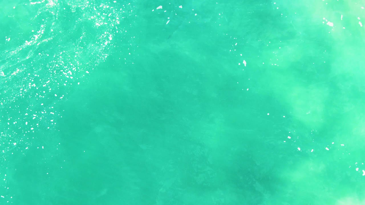 Blue-green ocean surface with ripples and bubbles