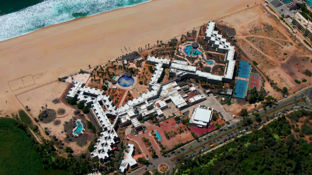 Aerial view of resort pools, beach, road, and vegetation