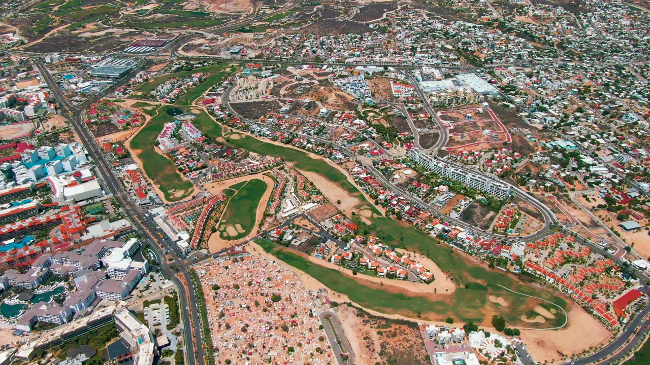 Overhead city view with central green space, roads, and surrounding development.