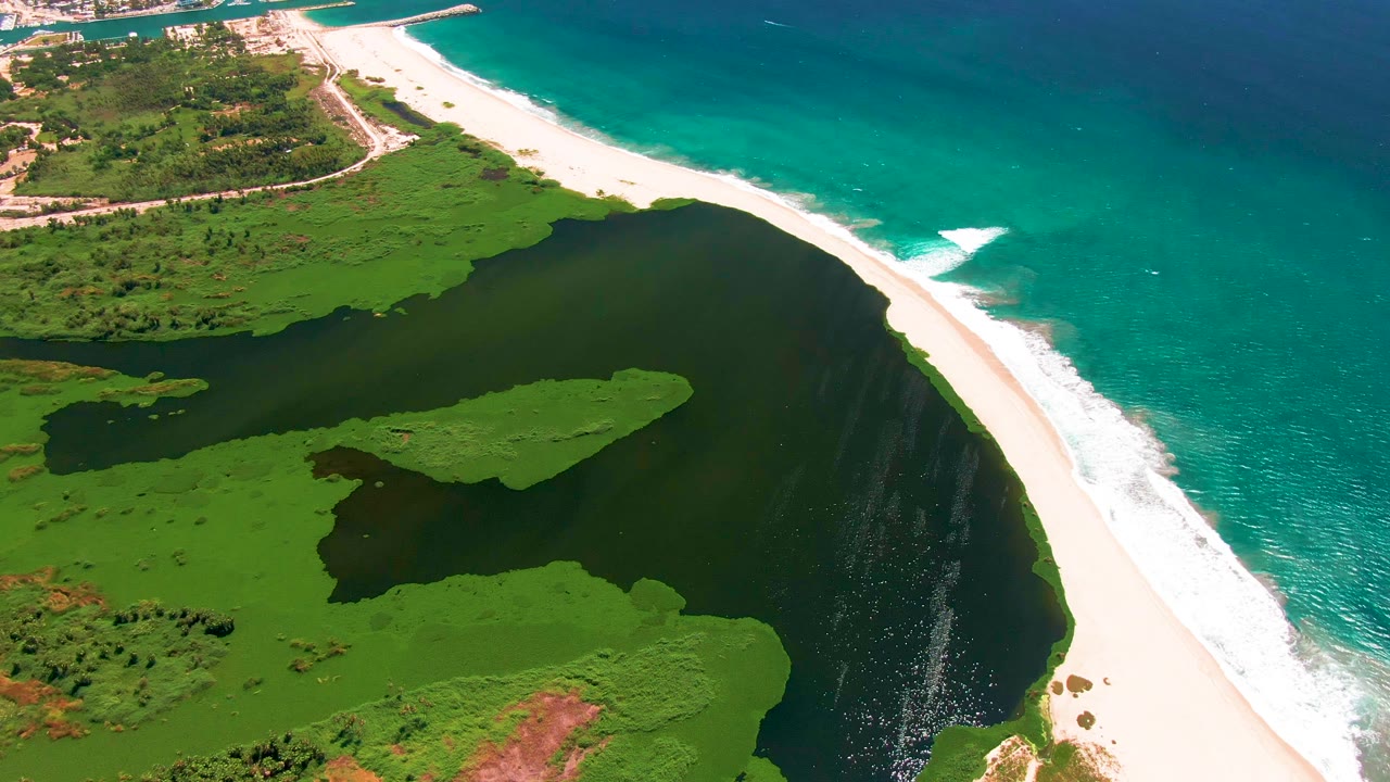 Aerial view in San Jose del Cabo with the lagoon filling the lower frame, the curved white beach separating it from turquoise ocean, and no visible people.