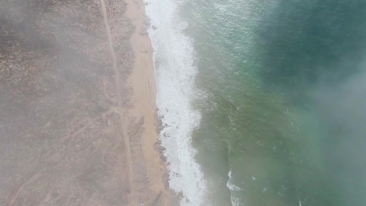 At 0:01, the Punta Gordo aerial view holds the beach and surf line near center while the blue green ocean fills the right side and no visible people appear.