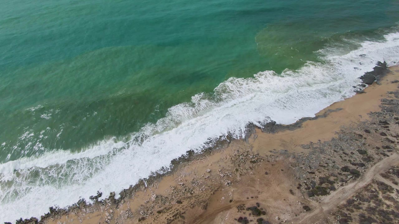 Aerial shoreline with surf covering the lower beach edge