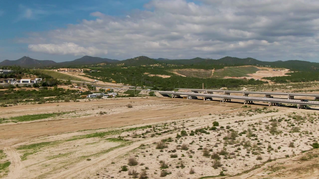 Road bridge crossing arid land with hills and clouds behind