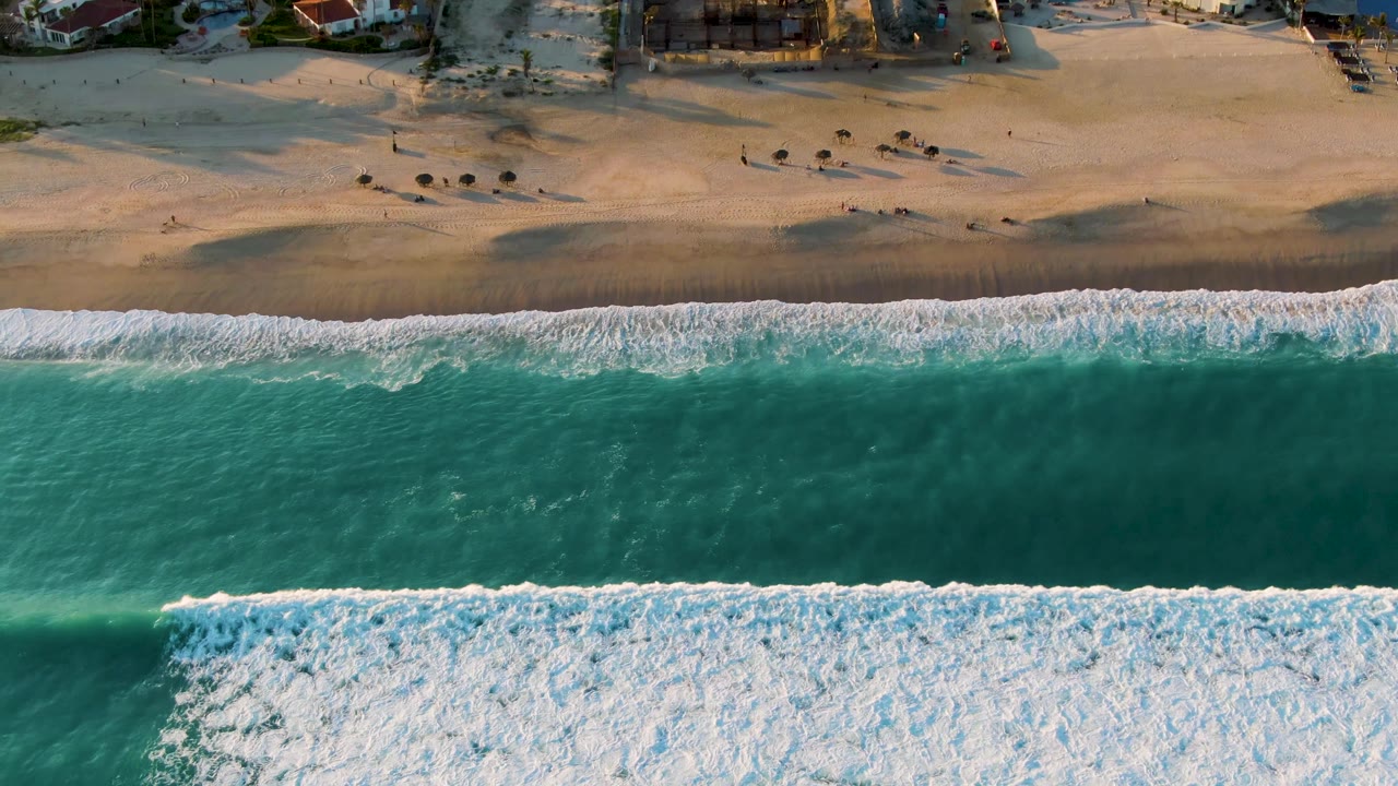 Aerial shoreline with a broad wave line approaching the beach