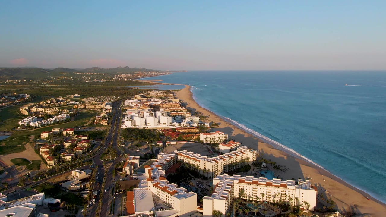 Aerial coastal resort area with road, beach, and broad ocean view