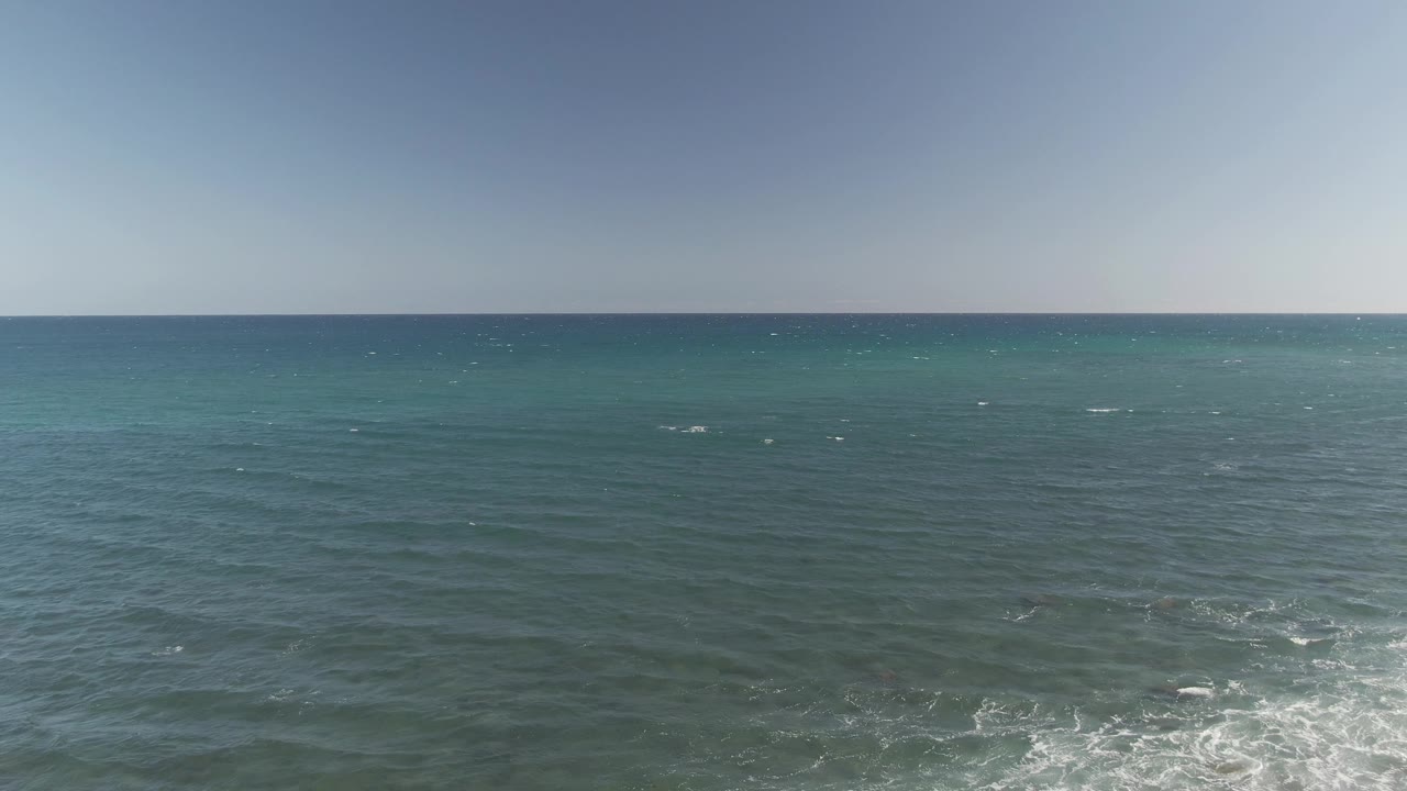 Wide ocean surface with horizon and pale sky