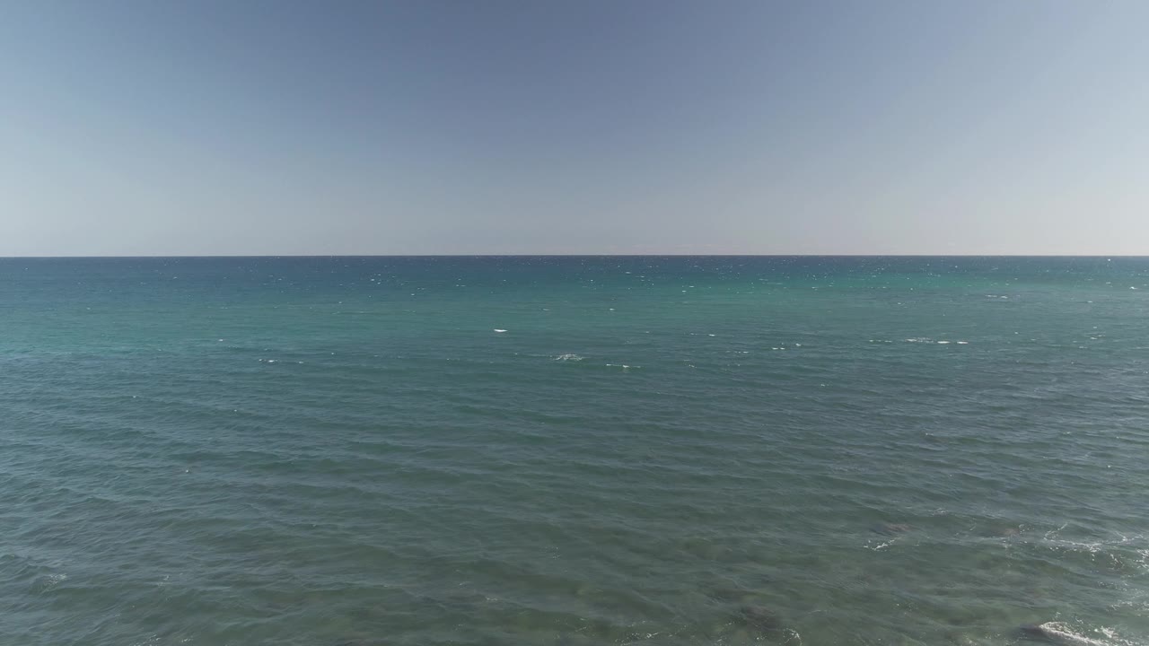 Costa Azul Los Cabos water fills the frame with scattered whitecaps, turquoise bands near the horizon, darker foreground chop, and no visible people.