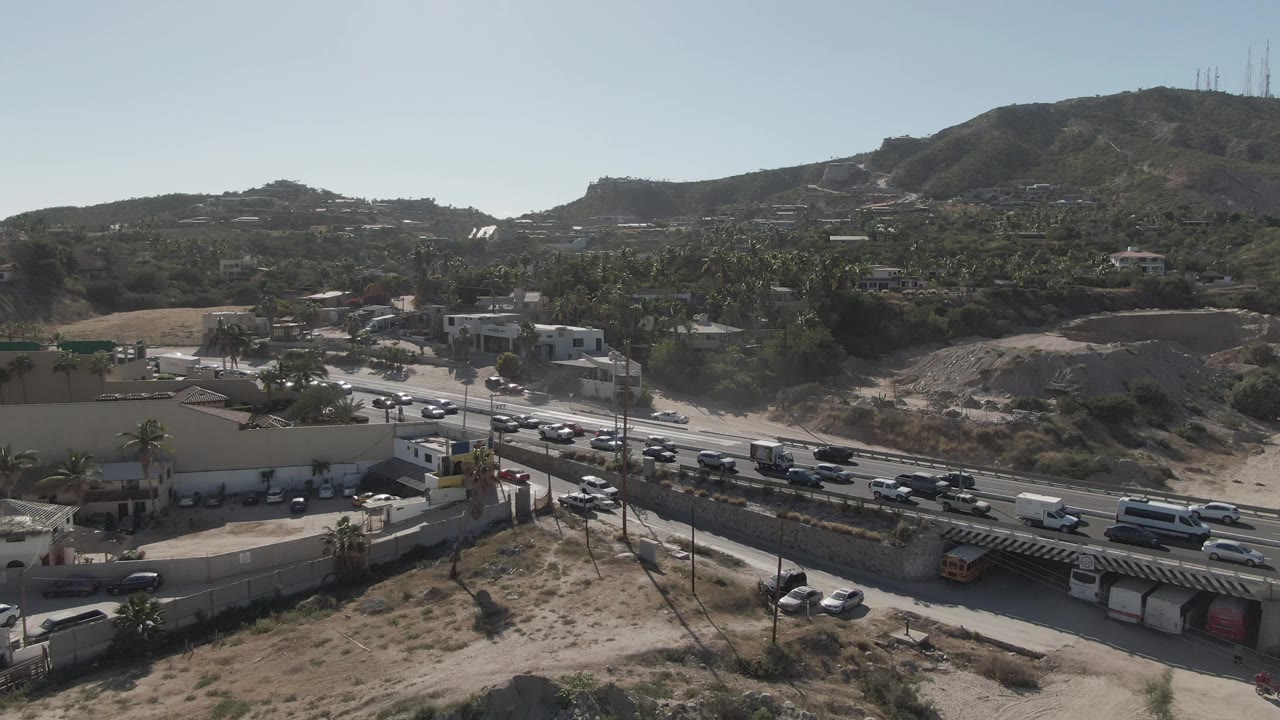 Elevated view of busy roadway and parking lot in dry terrain.
