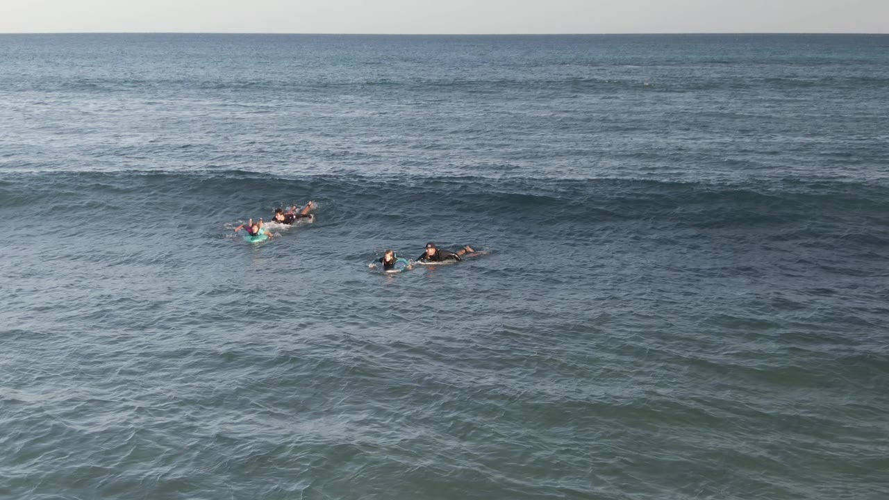 People on boards clustered near the cresting wave.