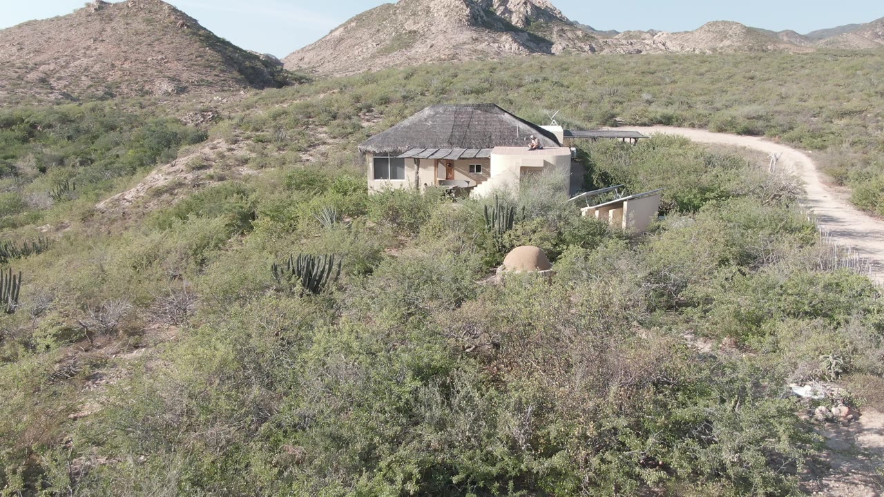 House and desert road set against low mountains