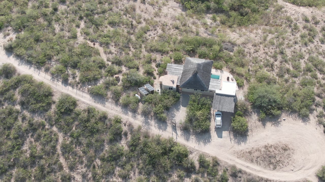 Aerial desert homestead with road crossing the left side