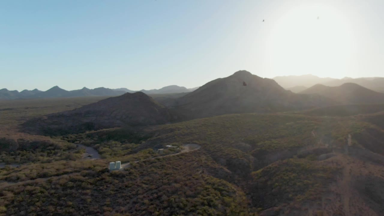 Bright sun over desert mountains and winding roads