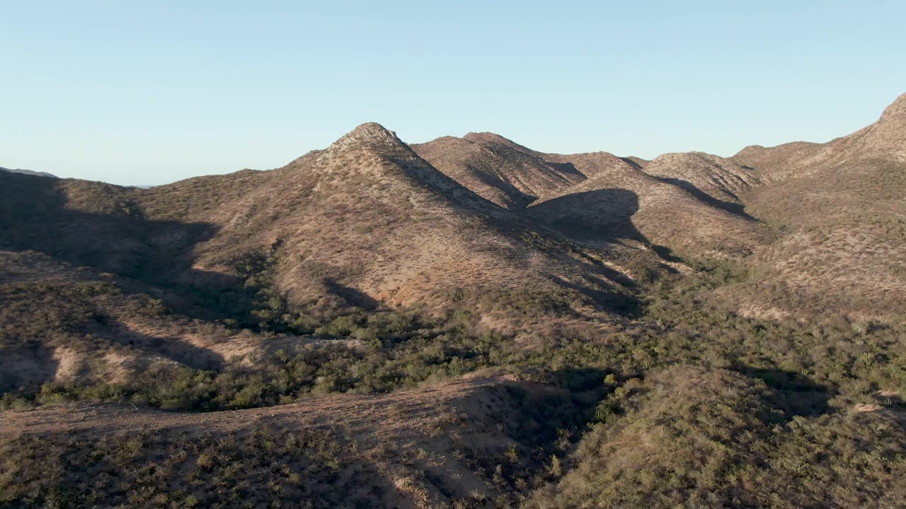 Dry hills and valley vegetation seen from above in clear light.